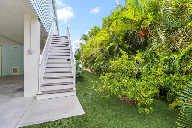 a view of a house with a yard and potted plants