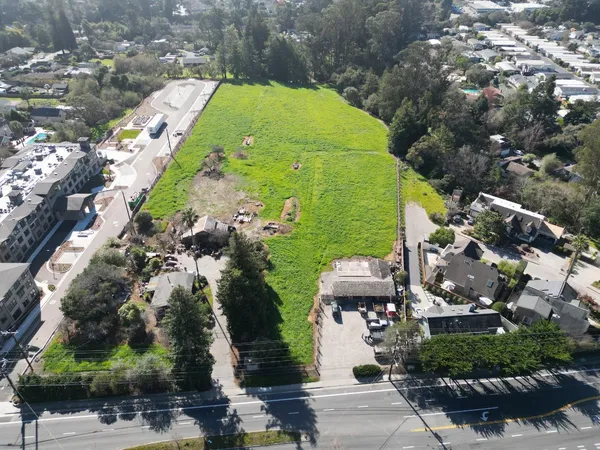 an aerial view of a residential houses with yard