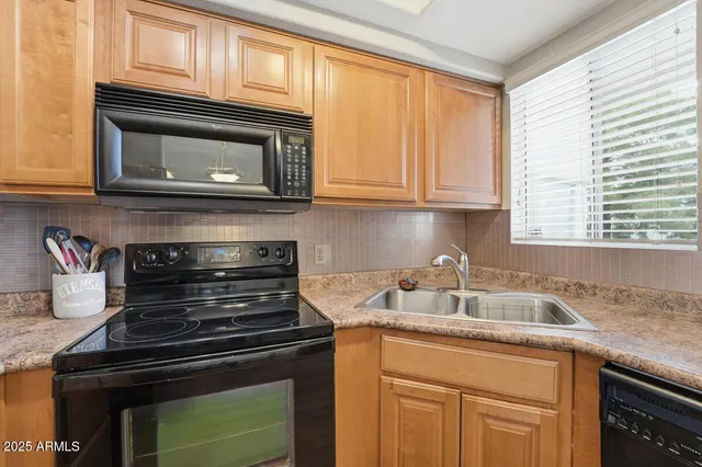 a kitchen with granite countertop a stove microwave and sink
