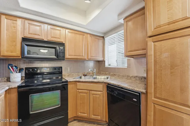 a kitchen with stainless steel appliances granite countertop white cabinets and a stove top oven