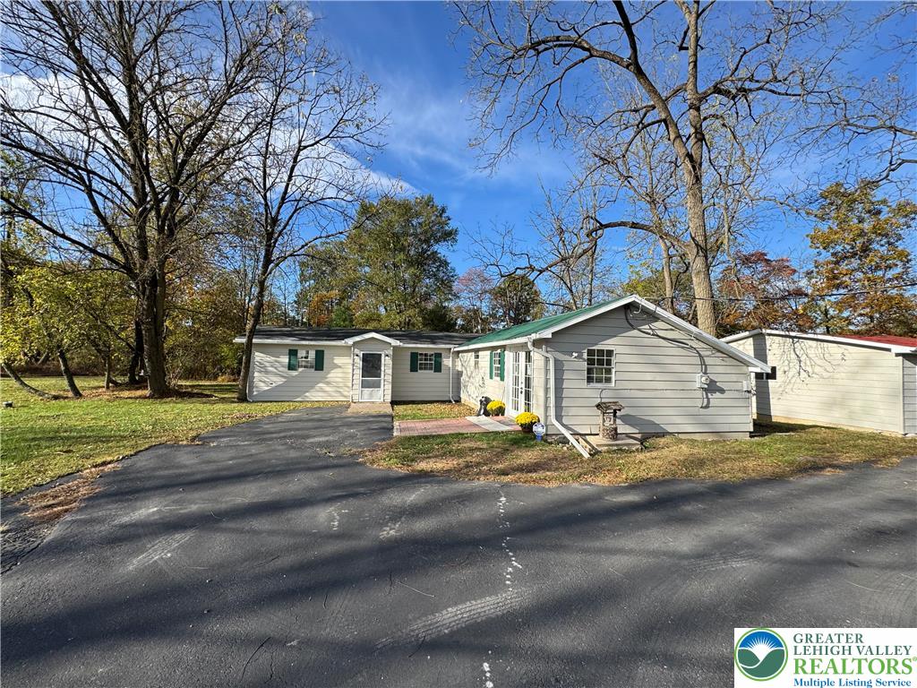 a view of a house with a yard and street