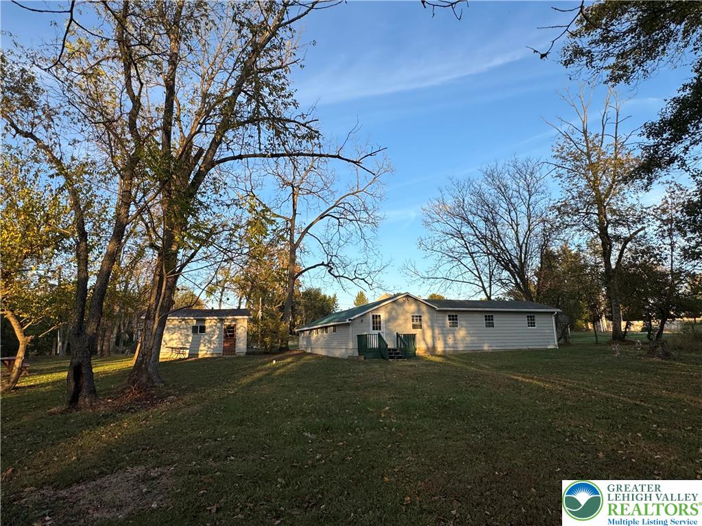 1071 Bitternut Road Walnutport, PA 18088 - Photo 23 of 39 a view of a white house next to a yard with big trees