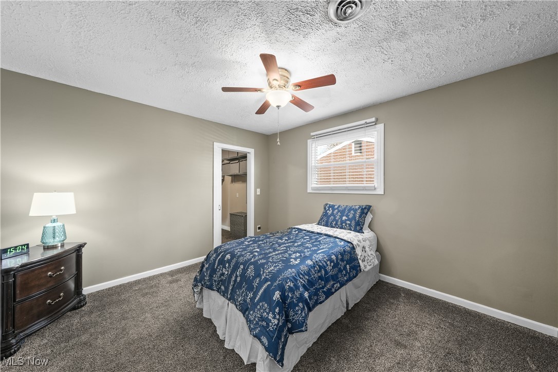 1503 Old Forge Road Kent, OH 44240 - Photo 18 of 38 Bedroom featuring a textured ceiling, dark colored carpet, and ceiling fan