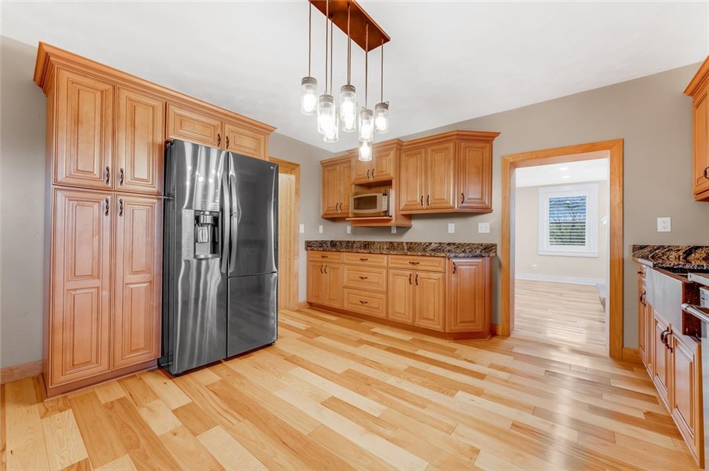 263 Goodwin Road Smithfield, PA 15478 - Photo 28 of 50 a kitchen with stainless steel appliances granite countertop a refrigerator oven a sink dishwasher and wooden cabinets with wooden floor