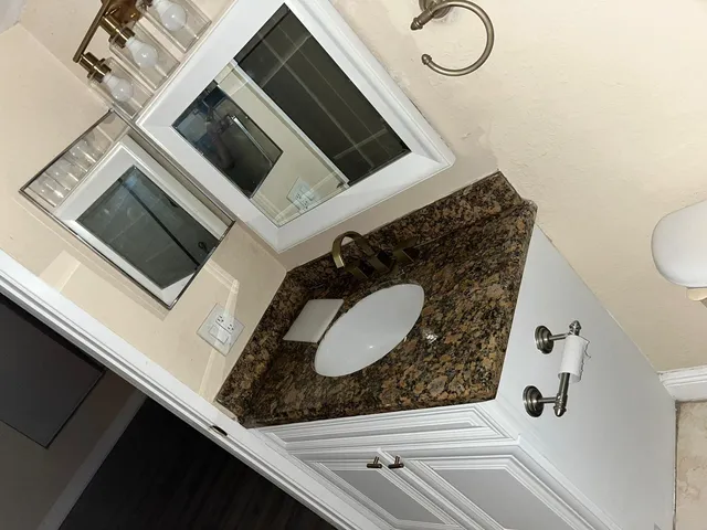 a kitchen with granite countertop white cabinets and stainless steel appliances