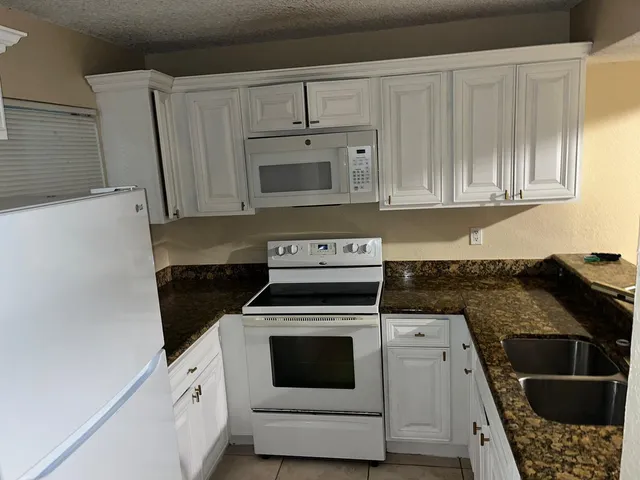 a kitchen with stainless steel appliances white cabinets and a stove top oven