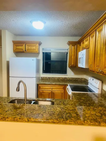 a kitchen with a stove top oven sink and cabinets