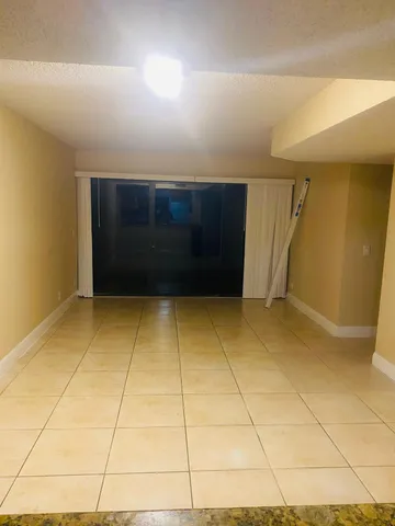 a view of an empty room with wooden floor and a fireplace
