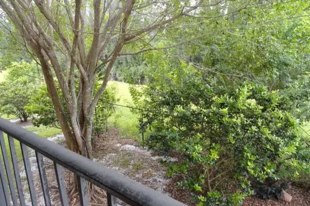 a living room with furniture a large window and a chandelier