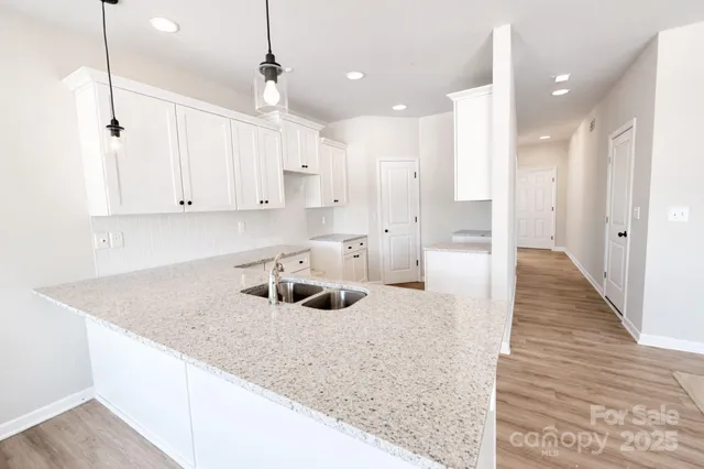 a kitchen with white cabinets sink and refrigerator