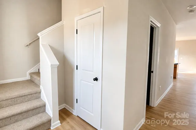 a view of a hallway with wooden floor and entryway