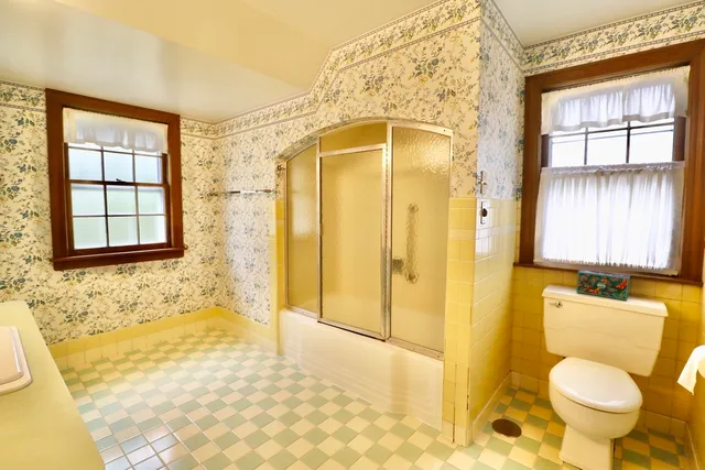 a bathroom with a granite countertop toilet and a shower