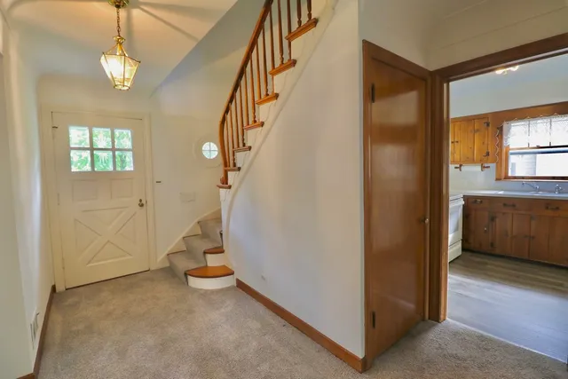 a view of a hallway with entryway and chandelier