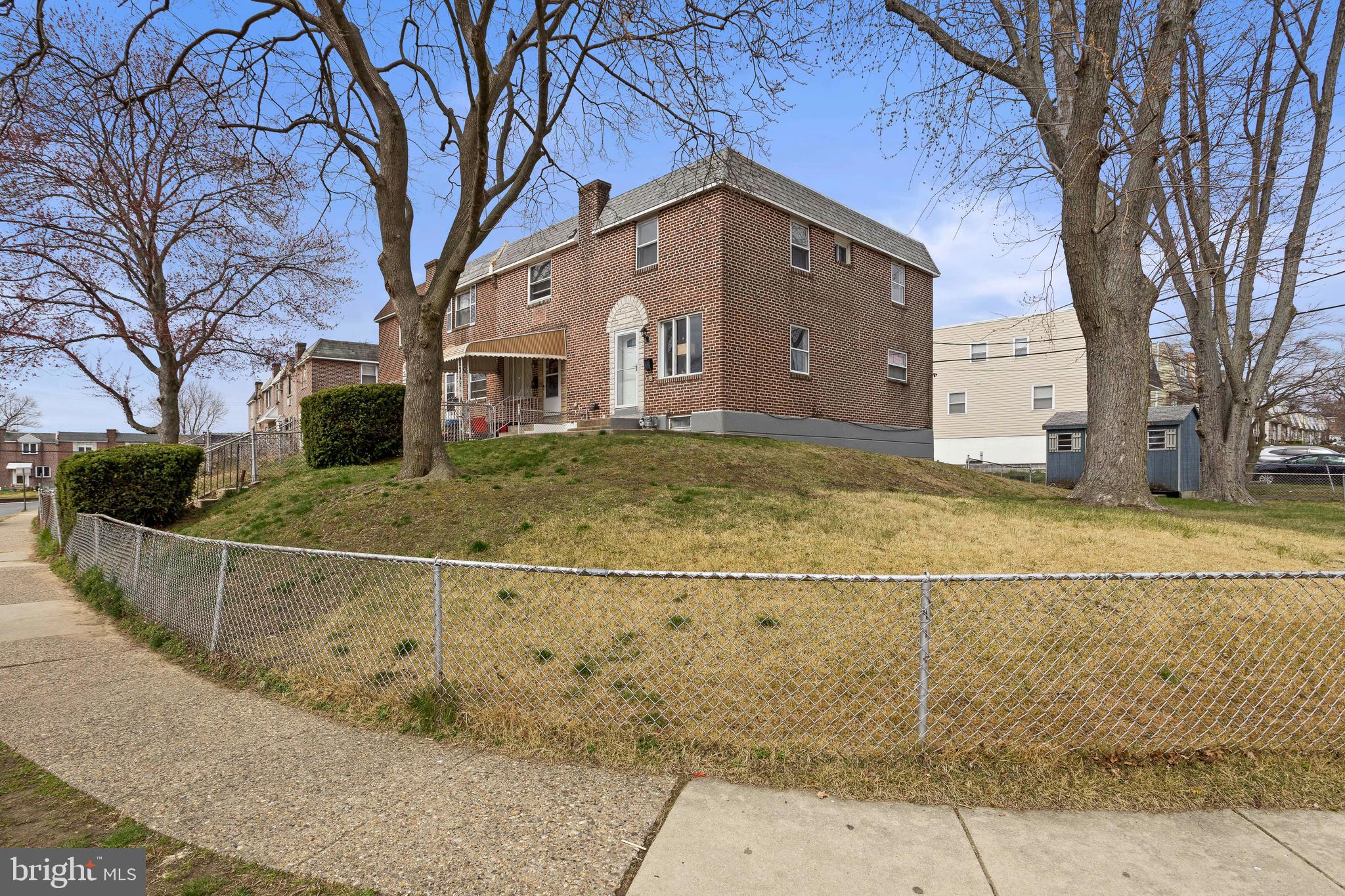 a view of a white house with a large tree