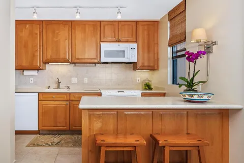 a kitchen with stainless steel appliances a sink cabinets and a window