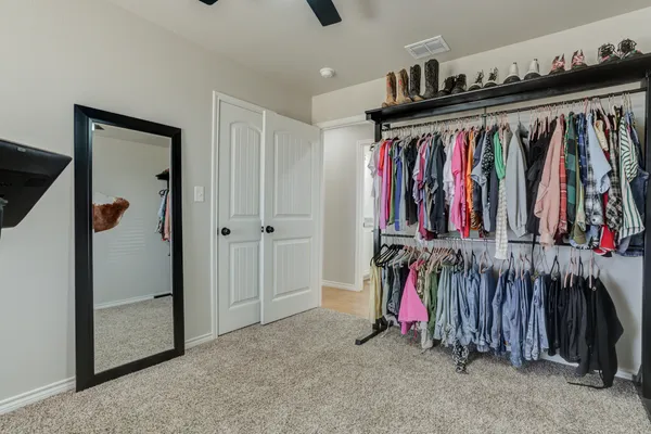 a view of walk in closet with clothes