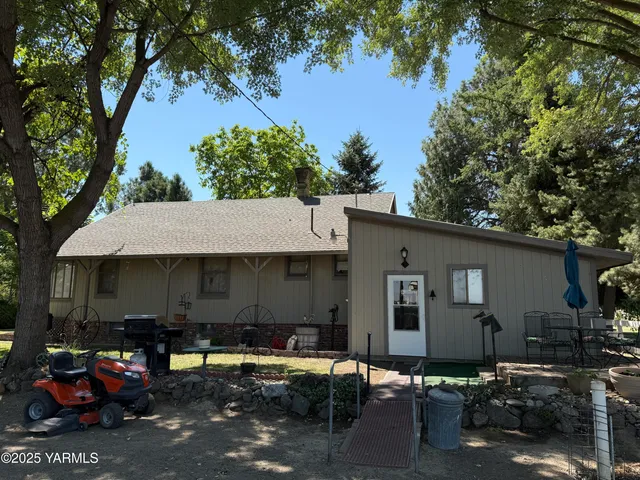 a couple of table and chairs in front of house
