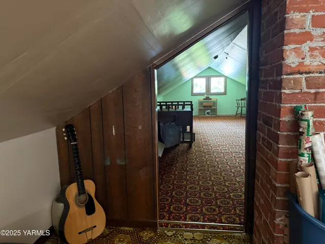 a bed sitting in a room next to a lamp