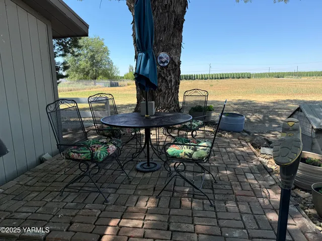 a backyard of a house with table and chairs