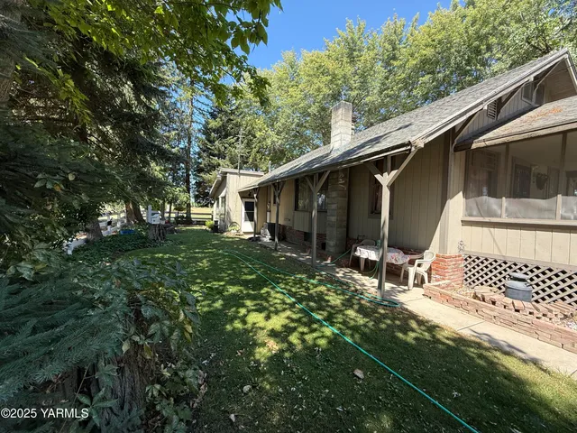 a backyard of a house with table and chairs