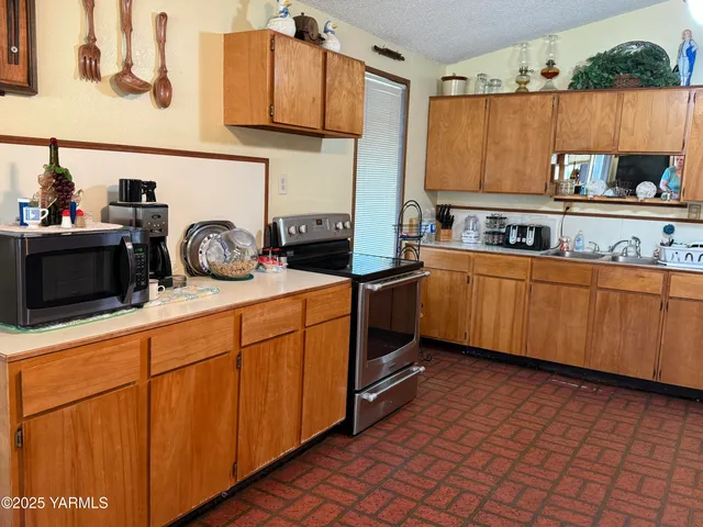 a kitchen with stainless steel appliances granite countertop a sink stove and cabinets
