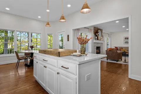 a living room with furniture a large window and wooden floor