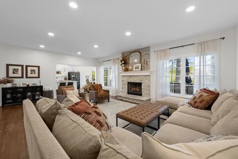 a living room with furniture fireplace and a large window