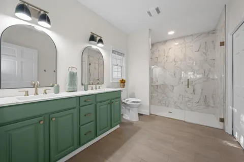 a spacious bathroom with a double vanity sink mirror and toilet