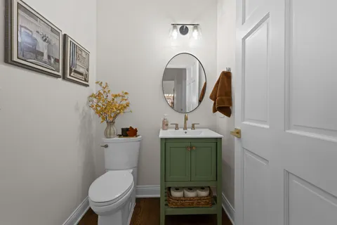 a bathroom with a toilet sink and mirror