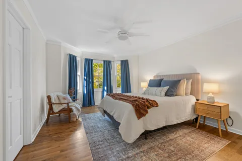a bedroom with a bed and large windows
