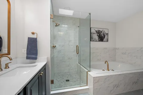 a bathroom with a sink a mirror a shower and a bathtub