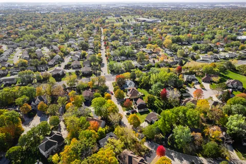 an aerial view of residential houses with outdoor space and trees