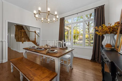 a view of a dining room with furniture a chandelier and wooden floor