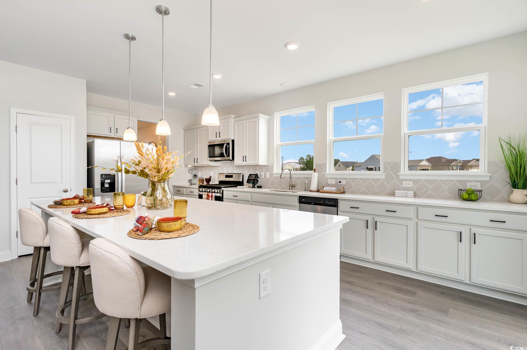 748 Doonbeg Court Conway, SC 29526 - Photo 7 of 30 Kitchen with backsplash, stainless steel appliances, a breakfast bar area, a center island, and decorative light fixtures