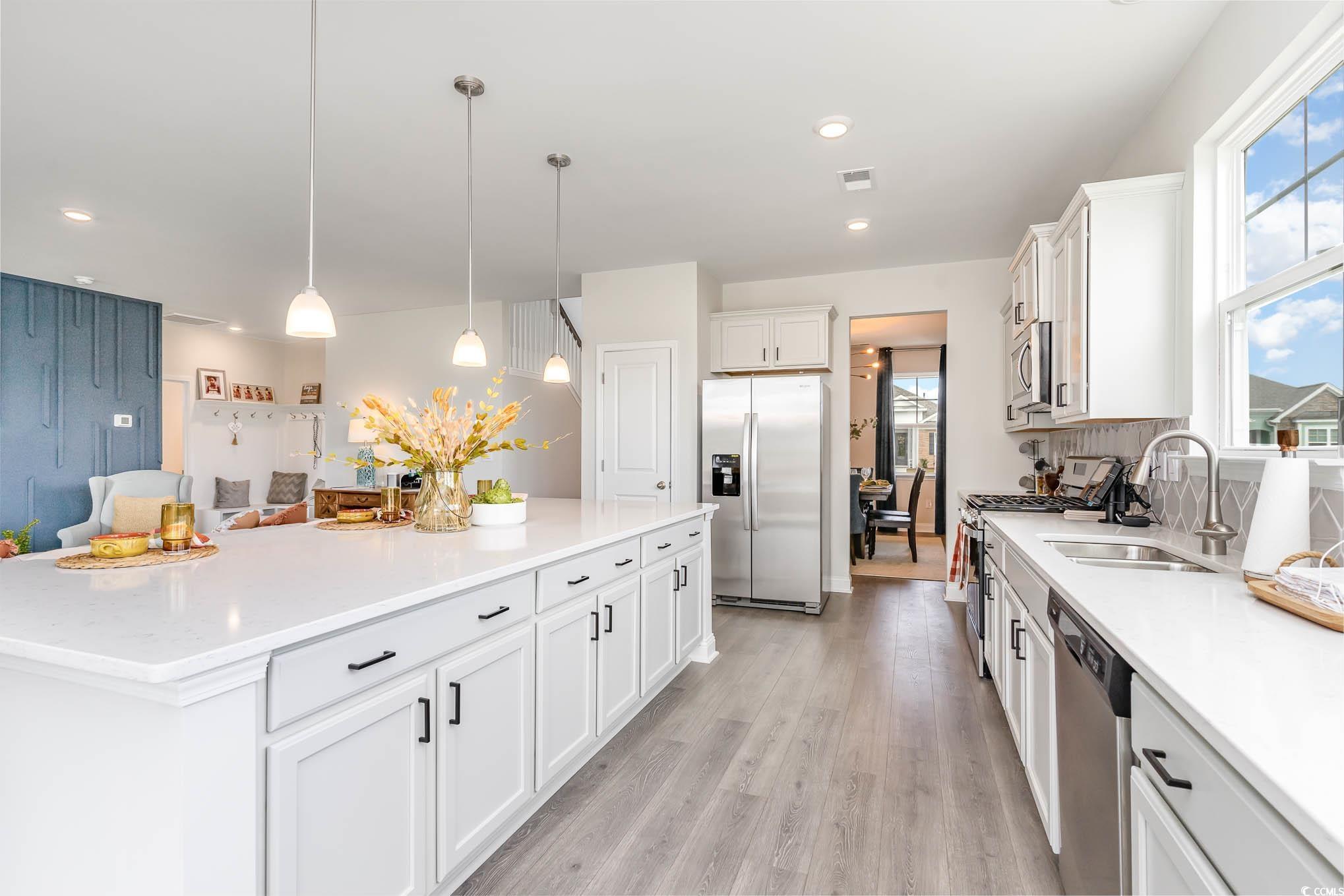 748 Doonbeg Court Conway, SC 29526 - Photo 8 of 30 Kitchen featuring stainless steel appliances, white cabinets, light countertops, light wood finished floors, and recessed lighting
