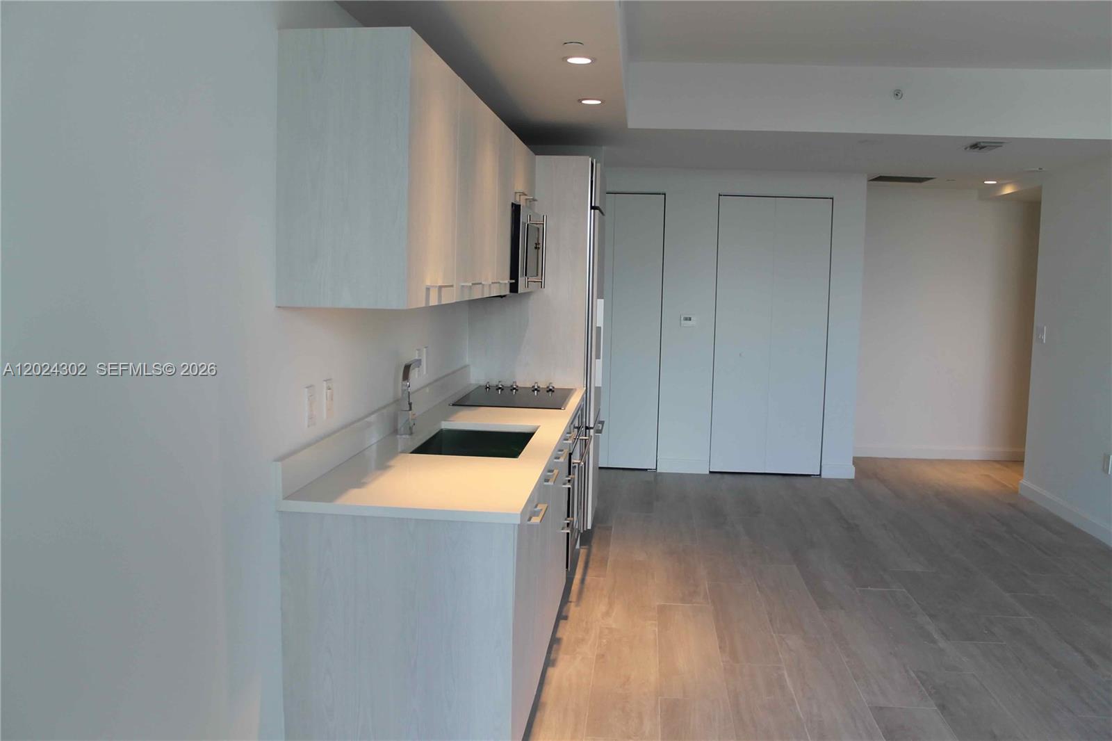 45 Southwest 9th Street, Unit 2109 Miami, FL 33130 - Photo 3 of 40 a view of a kitchen with a sink and a refrigerator