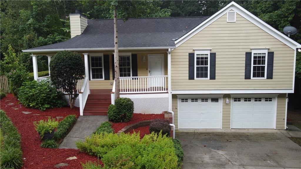 a front view of a house with a yard and potted plants