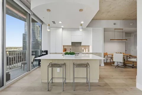 a kitchen with kitchen island a stove a table and chairs in it