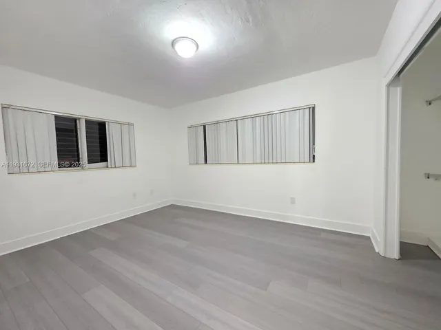 an empty room with wooden floor and closet