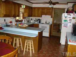 6020 Spring Valley Drive Raleigh, NC 27616 - Photo 4 of 10 a kitchen with a refrigerator and a stove top oven