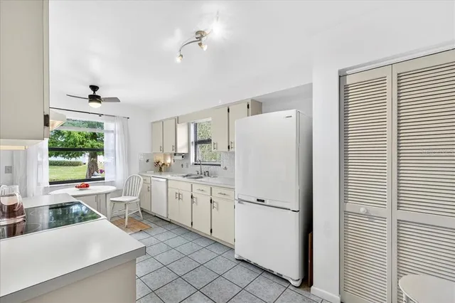 a kitchen with white cabinets and white appliances
