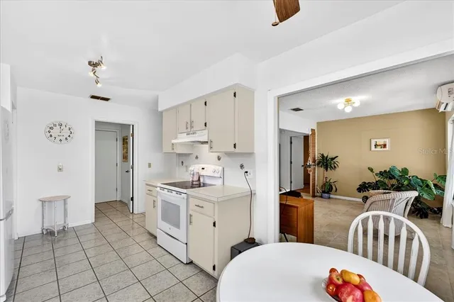 a large white kitchen with a sink and dishwasher a refrigerator with white cabinets