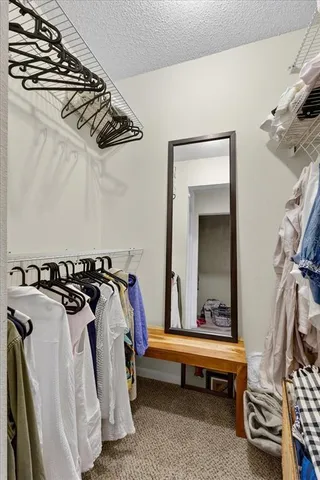 a view of walk in closet with clothes and shoes