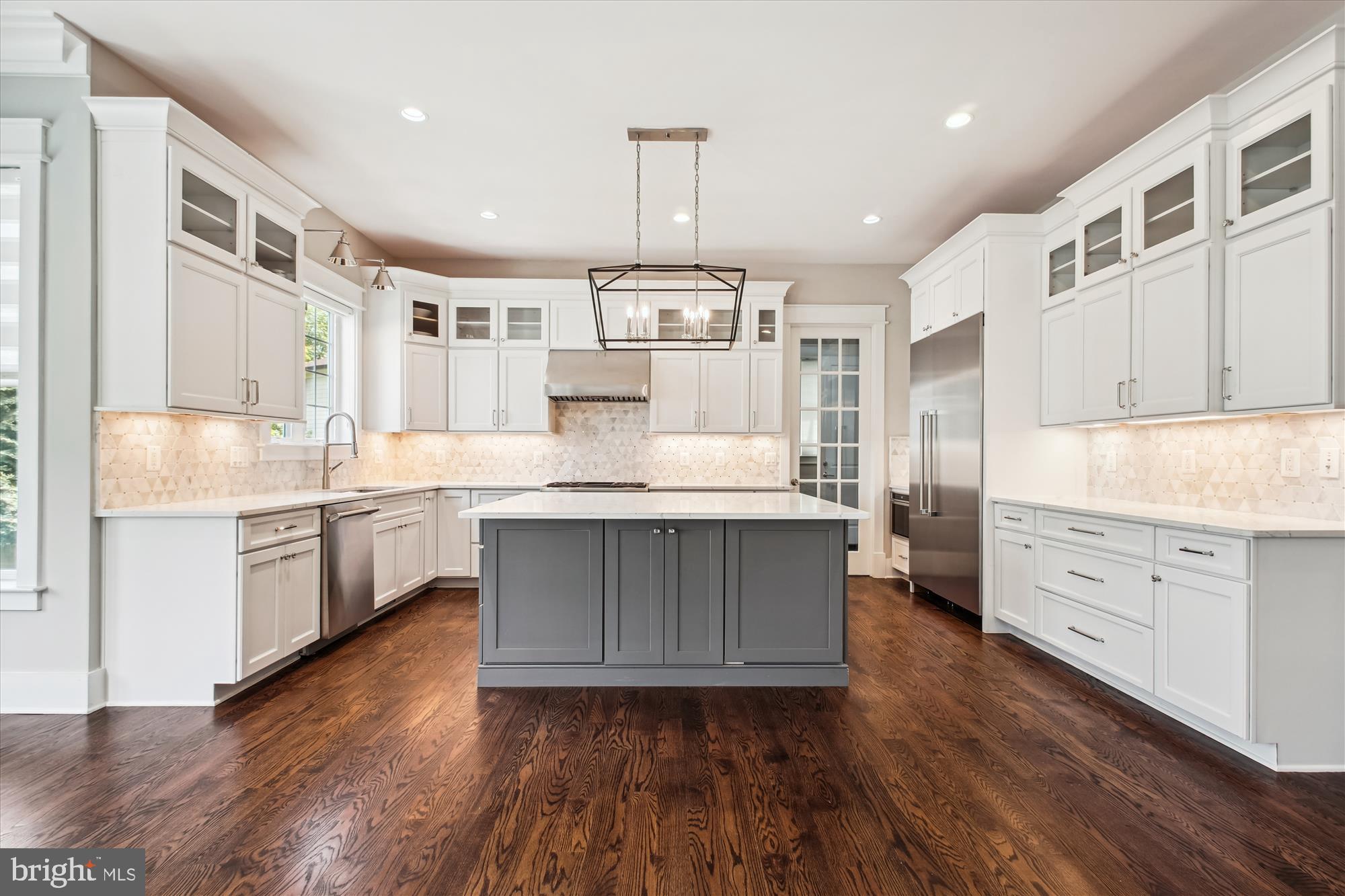 1565 Hane Street McLean, VA 22101 - Photo 7 of 43 a kitchen with kitchen island granite countertop a sink cabinets and wooden floor