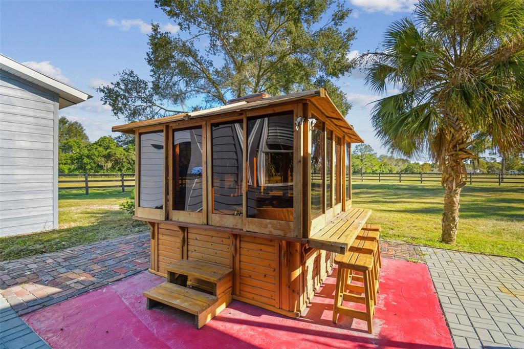 12714 Tyler Run Avenue Odessa, FL 33556 - Photo 40 of 65 a view of a backyard with chairs and floor to ceiling window