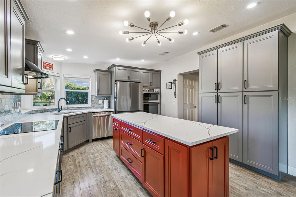 12714 Tyler Run Avenue Odessa, FL 33556 - Photo 8 of 65 a kitchen with kitchen island a sink appliances and cabinets