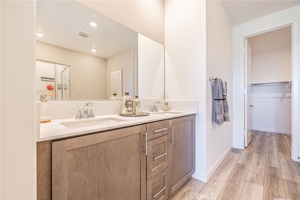27555 Sanctuary Court Stevenson Ranch, CA 91381 - Photo 17 of 29 a bathroom with a double vanity sink a mirror and a shower