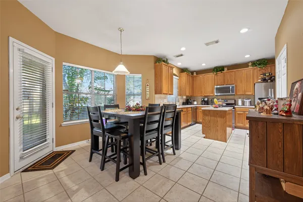 a dining hall with stainless steel appliances a table and chairs