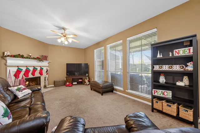 a living room with furniture a flat screen tv and a window