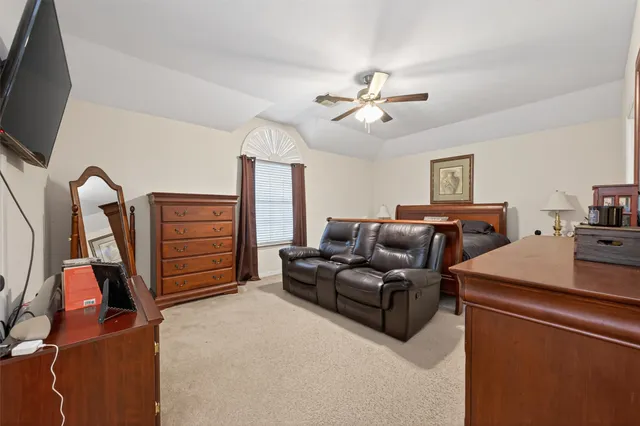 a living room with furniture a flat screen tv and gym equipment